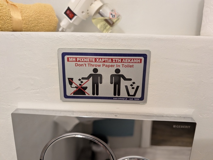 A sign next to a toilet